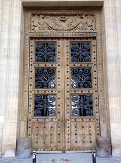 an ornate wooden door with wrought iron work on the front entrance to a large building