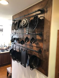 a wall mounted rack with pots and pans on it