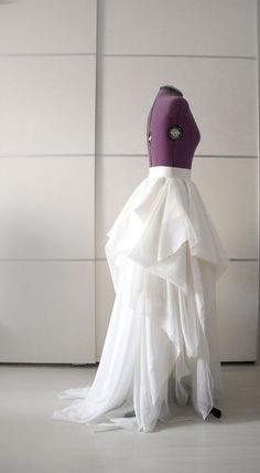 a mannequin wearing a white and purple dress