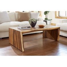 a wooden table sitting on top of a hard wood floor next to a white couch