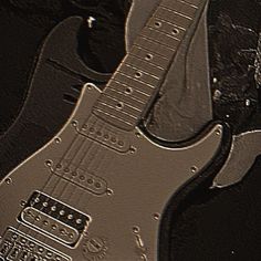 an electric guitar sitting on top of a black surface