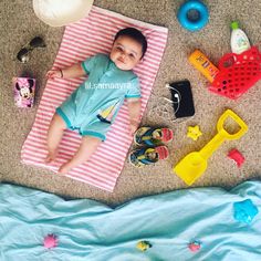 a baby laying on top of a blanket next to toys