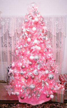 a pink christmas tree decorated with ornaments