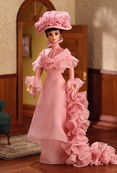 a barbie doll wearing a pink dress and hat with flowers on it's head