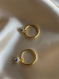 14K Gold plated 925 Sterling Silver Charm Hoop Earrings. Minimalist style. Everyday jewelry made with love. DETAILS * 14K Gold Plated * 925 Sterling Silver * AAA Cubic Zirconia Stone * Also available in 14K White Gold * Lead Free and Nickel Free MEASURES Hoop Diameter: 12mm (1.2cm) Stud Size: 5mm (1cm) *Sell as a pair PACKAGE: All jewelry comes in beautiful packaging, gift ready. ABOUT FALA All our work is made with love in Santa Monica, California. We love our customers and will make sure you'r Gift Single Hoop Earring, Gold Plated Hoop Cartilage Earring, Gold Plated Single Hoop Cartilage Earring, Gold Plated Single Circle Earring, Single Circle Earring For Anniversary, Uncut Diamond Necklace, Gold Earrings For Kids, Gold Huggie Earrings, Simple Gold Earrings