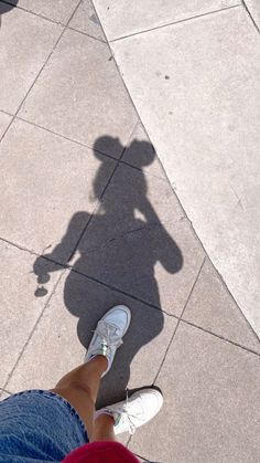 the shadow of a person standing next to a skateboard