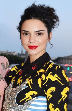 a woman with black hair and red lipstick