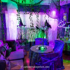 a living room decorated with purple and green lighting for halloween party decorations in the shape of witches