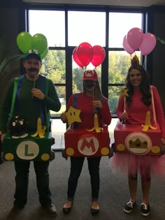 three people dressed up in costumes and holding balloons