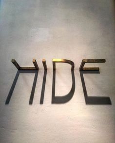 the word idf spelled in gold letters on a white wall with shadow from it