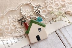 a house shaped keychain sitting on top of a piece of paper next to flowers