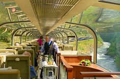 the inside of a train car with people on it and one man standing at the back