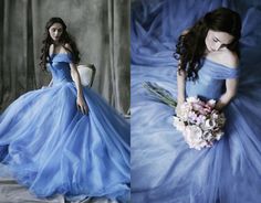 a woman in a blue dress sitting on a chair and holding a bouquet of flowers