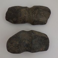 two rocks sitting next to each other on a white surface