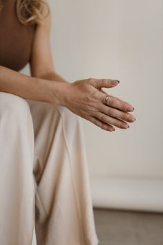 a woman is sitting on the floor with her hands together