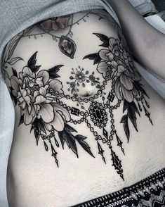 a woman's stomach with flowers and chains on it