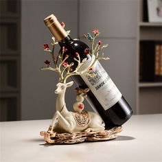 a bottle of wine sitting next to a deer figurine on top of a table