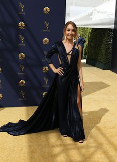 a woman in a black dress standing on a yellow carpet