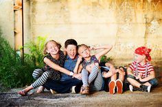 three children are sitting on the ground with their arms around each other and one child is holding his head