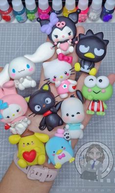 there are many small toy animals on the palm of someone's hand, all in different colors