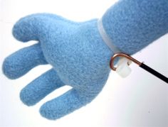 a blue glove with an earpiece attached to it's thumb is being held by a hand