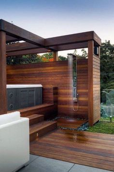 an outdoor shower in the middle of a wooden decked area with a hot tub