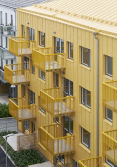 an apartment building with yellow balconies and windows