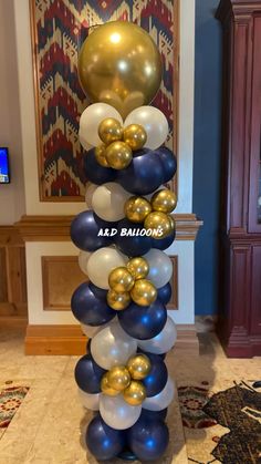 a tall balloon column with gold and blue balloons