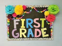 the first grade sign is decorated with colorful flowers and pom poms on it