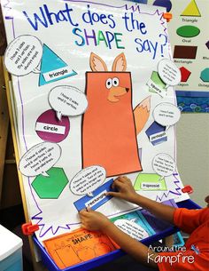 a young boy writing on a poster in front of a classroom wall that says, what does the shape say?