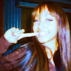 a young woman brushing her teeth with an electric toothbrush