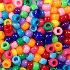 there are many different colored beads on the table