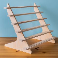 a wooden shelf sitting on top of a hard wood floor next to a blue wall