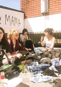 several women sitting on the ground with some water bottles