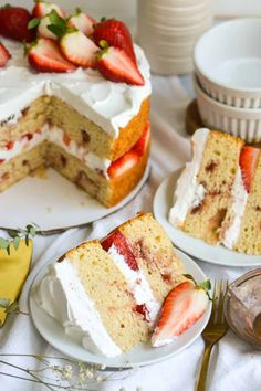 two plates with slices of cake and strawberries on them