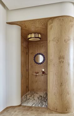 a curved wooden room with a mirror on the wall