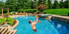 a young boy is playing in the pool with his mom and dad, who are both wearing swim trunks