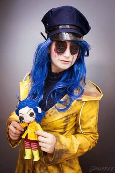 a woman with blue hair wearing a yellow raincoat and holding a stuffed animal doll