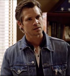 a man in a denim jacket looking at the camera