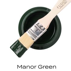 a close up of a paint brush with the words manor green painted on it's side