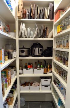 an organized pantry with white shelving and lots of food in bins on the shelves