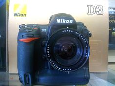 a digital camera sitting on top of a table next to a box with the nikon d3 logo