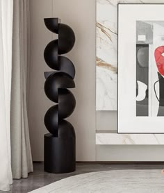 there is a black sculpture next to a red heart on the wall in this living room