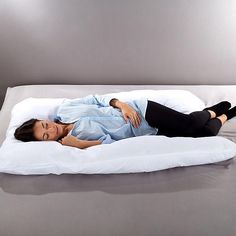 a woman laying on top of a white pillow