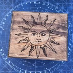 a wooden box with an image of the sun on it's face and stars in the background