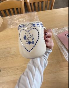 a person holding a coffee mug with an elephant on it's sleeve and the handle