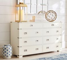 a white dresser sitting next to a blue rug