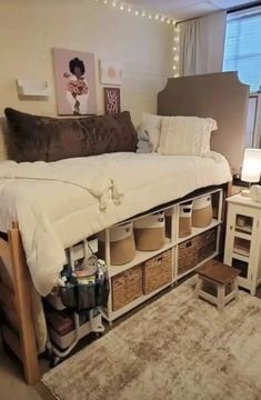 a bedroom with a bed, desk and storage drawers in front of a large window