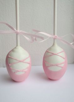 two candy lollipops with pink and white stripes on them, tied together