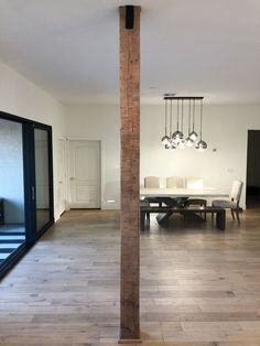 an empty living room with wood floors and chandelier hanging from the ceiling,